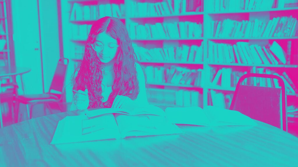 A Girl Reading Book while Sitting on a Chair Inside the Library - September 2016 LSAT Score Release Date