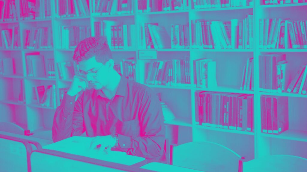 Man Reading a Book Inside the Library