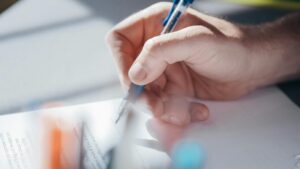 Hand filling out law school application form with pen