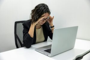 Stressed student staring at her laptop, overwhelmed by LSAT prep and upcoming test deadlines.